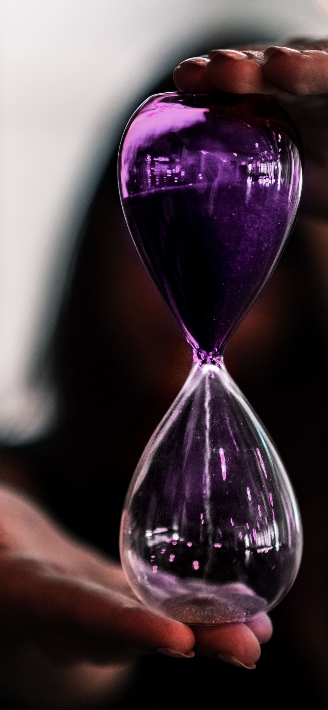 Purple Hour Glass on Persons Hand. Wallpaper in 1125x2436 Resolution