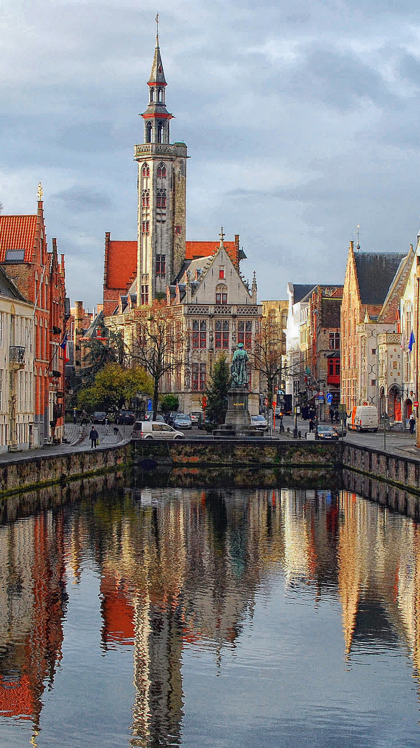 Brown and White Concrete Buildings Beside River Under White Clouds During Daytime. Wallpaper in 1440x2560 Resolution
