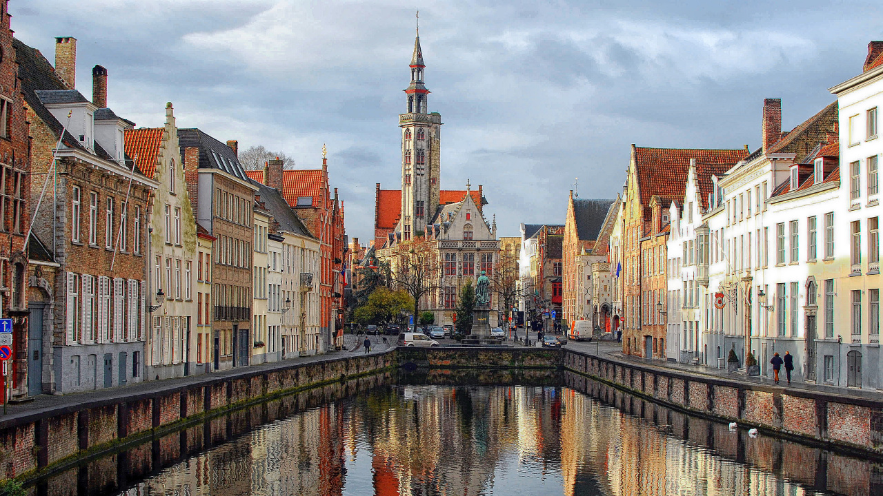Braune Und Weiße Betongebäude Neben Dem Fluss Unter Weißen Wolken Tagsüber. Wallpaper in 1280x720 Resolution