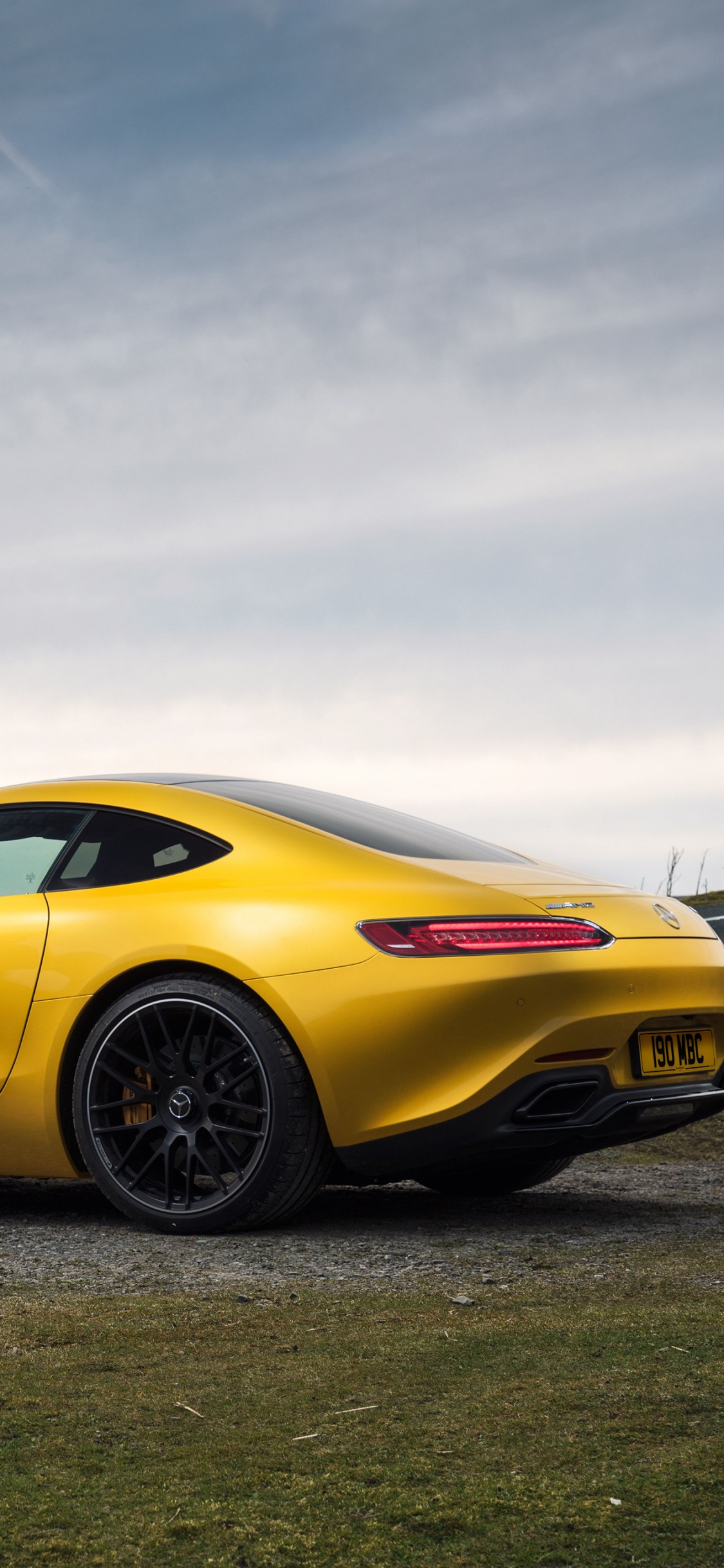 Yellow Ferrari 458 Italia on Gray Asphalt Road Under Gray Cloudy Sky. Wallpaper in 1125x2436 Resolution