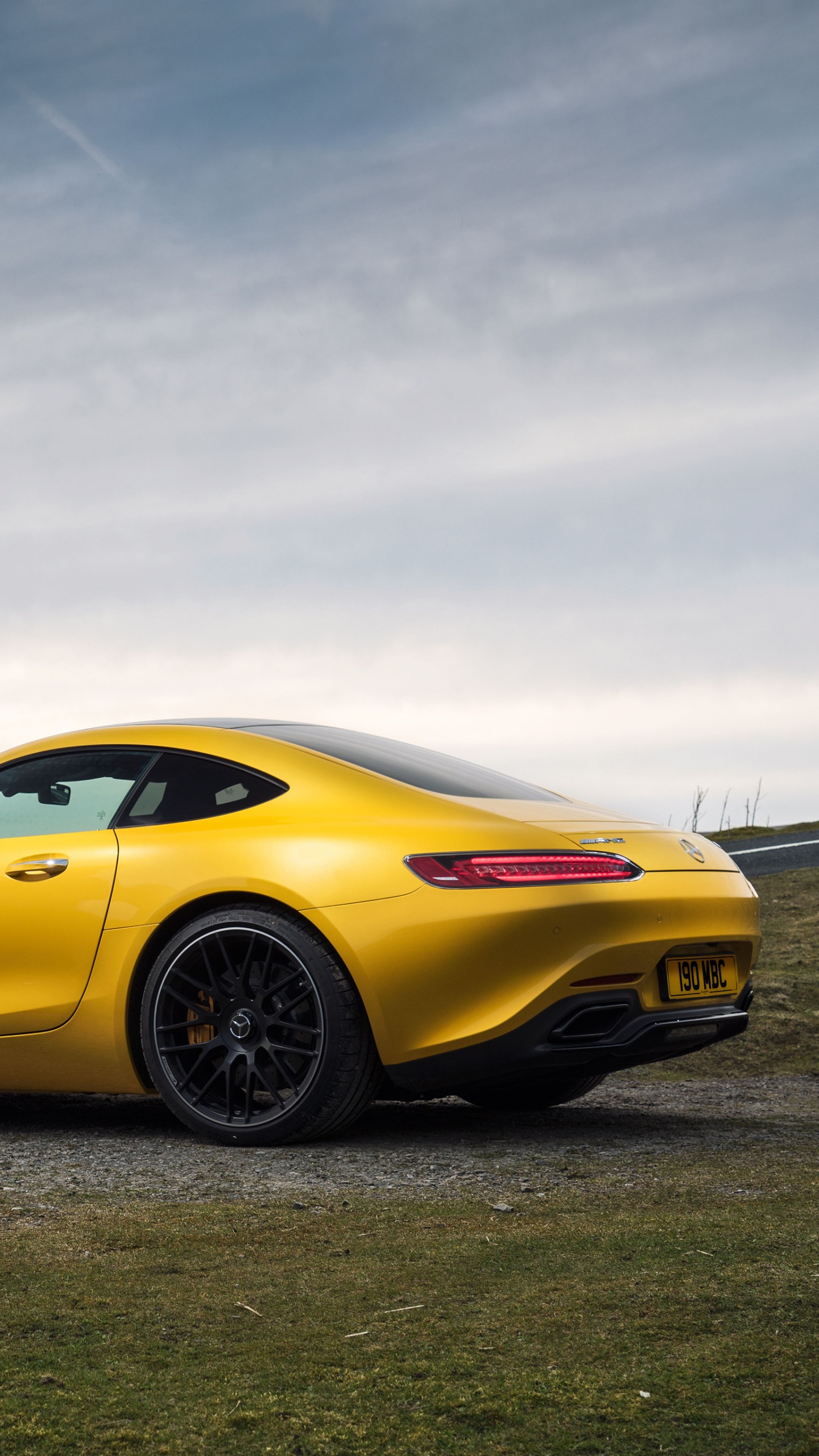 Yellow Ferrari 458 Italia on Gray Asphalt Road Under Gray Cloudy Sky. Wallpaper in 1440x2560 Resolution