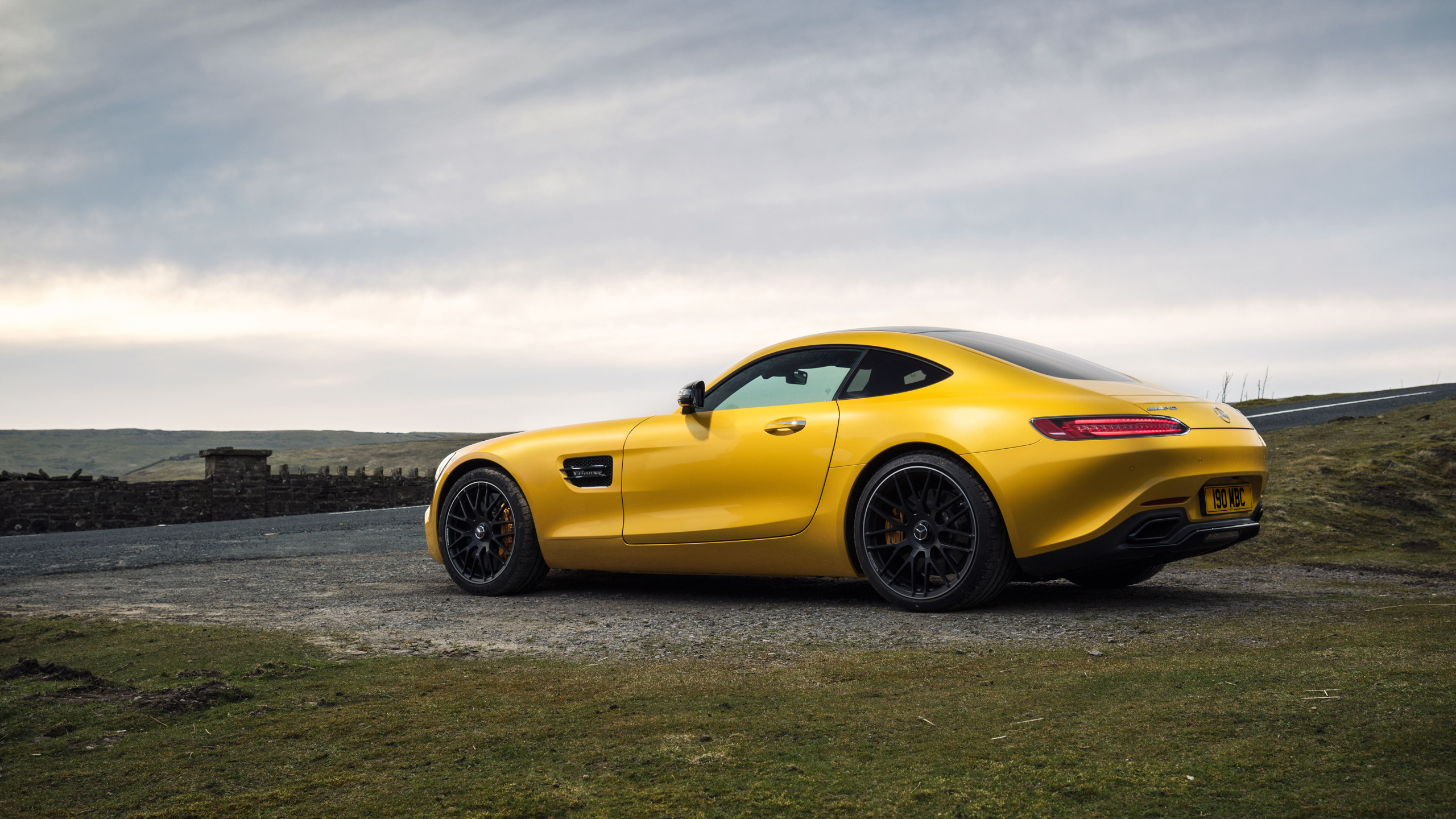 Yellow Ferrari 458 Italia on Gray Asphalt Road Under Gray Cloudy Sky. Wallpaper in 2560x1440 Resolution