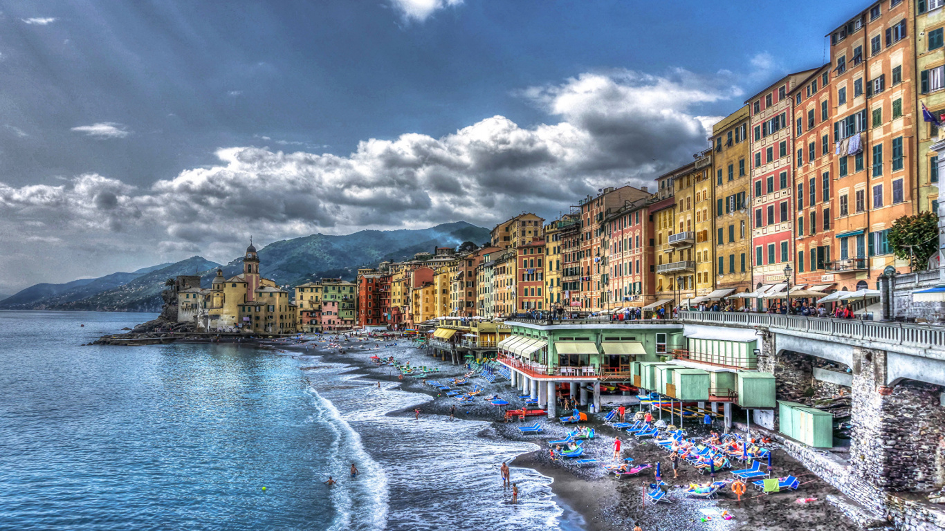 People on Beach Near Buildings Under Cloudy Sky During Daytime. Wallpaper in 1366x768 Resolution