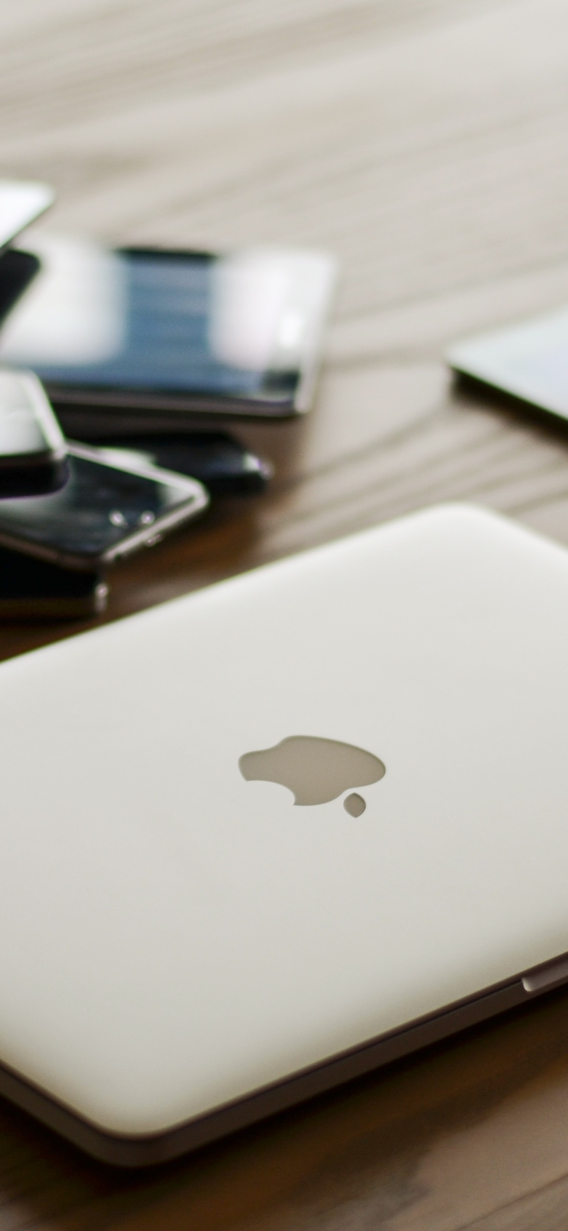 Silbernes MacBook Auf Braunem Holztisch. Wallpaper in 1125x2436 Resolution