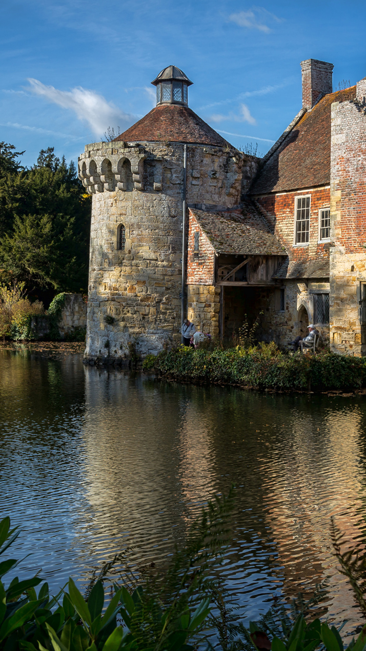 Brown Brick Building Beside Body of Water Under Blue Sky During Daytime. Wallpaper in 750x1334 Resolution