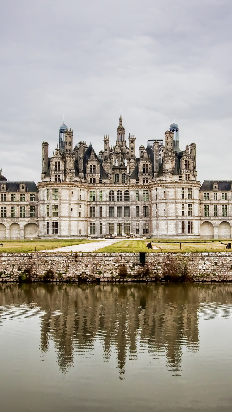 Bâtiment en Béton Blanc Près D'un Plan D'eau Pendant la Journée. Wallpaper in 750x1334 Resolution