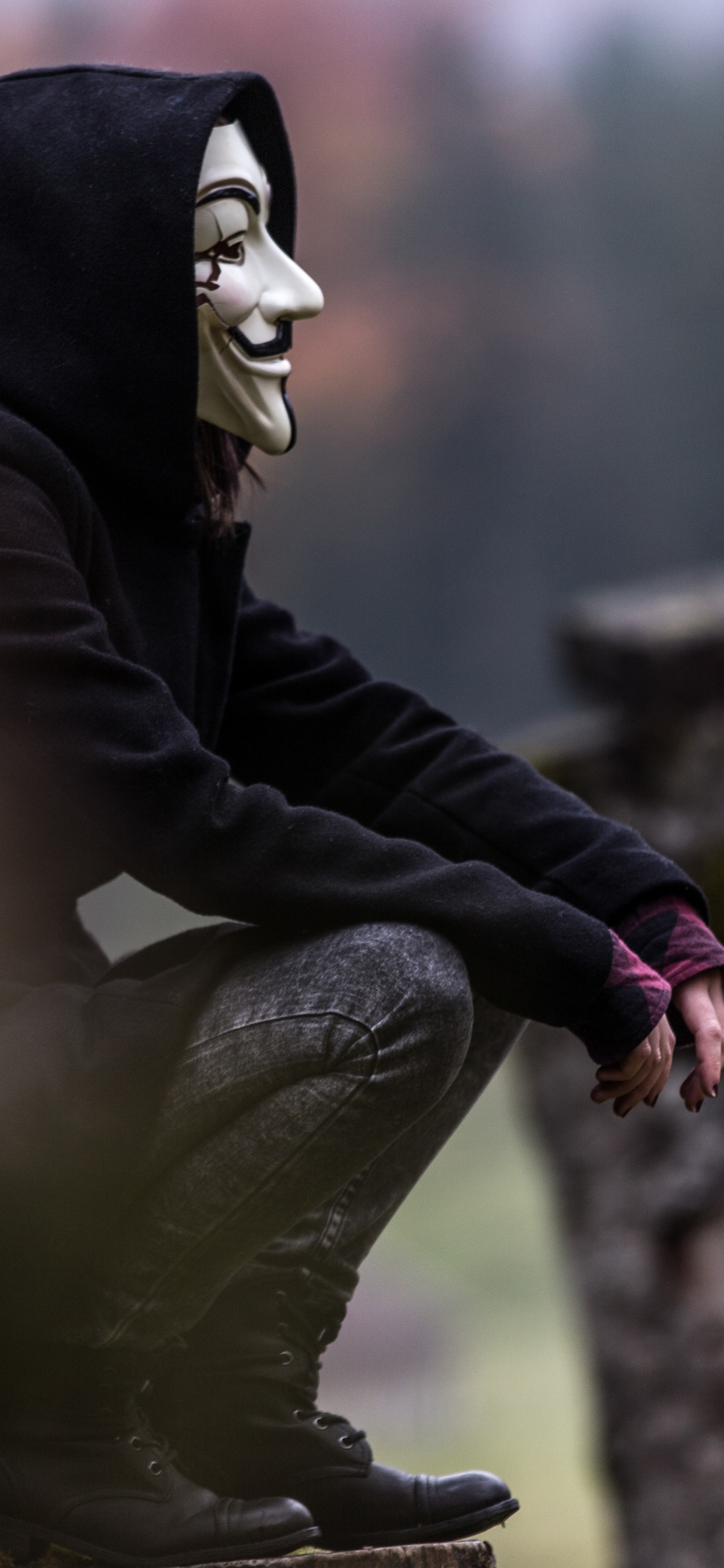 Person in Black and White Mask and Black Jacket Sitting on Rock. Wallpaper in 1242x2688 Resolution