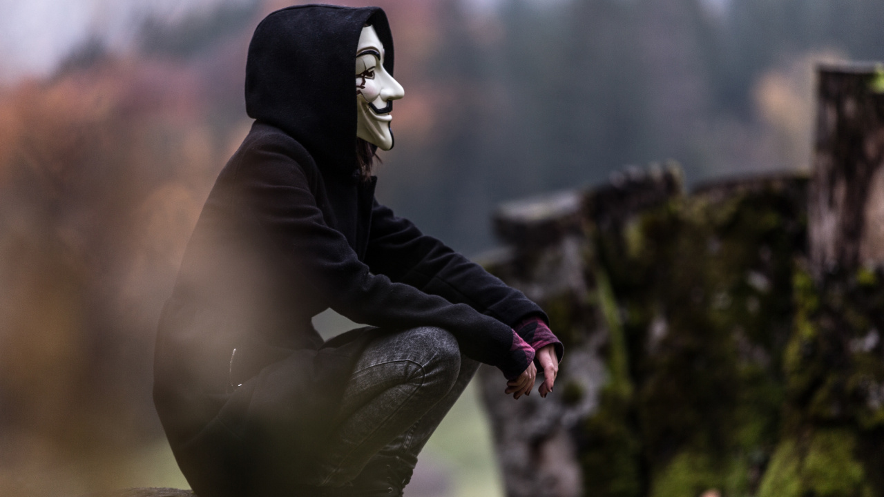 Person in Black and White Mask and Black Jacket Sitting on Rock. Wallpaper in 1280x720 Resolution
