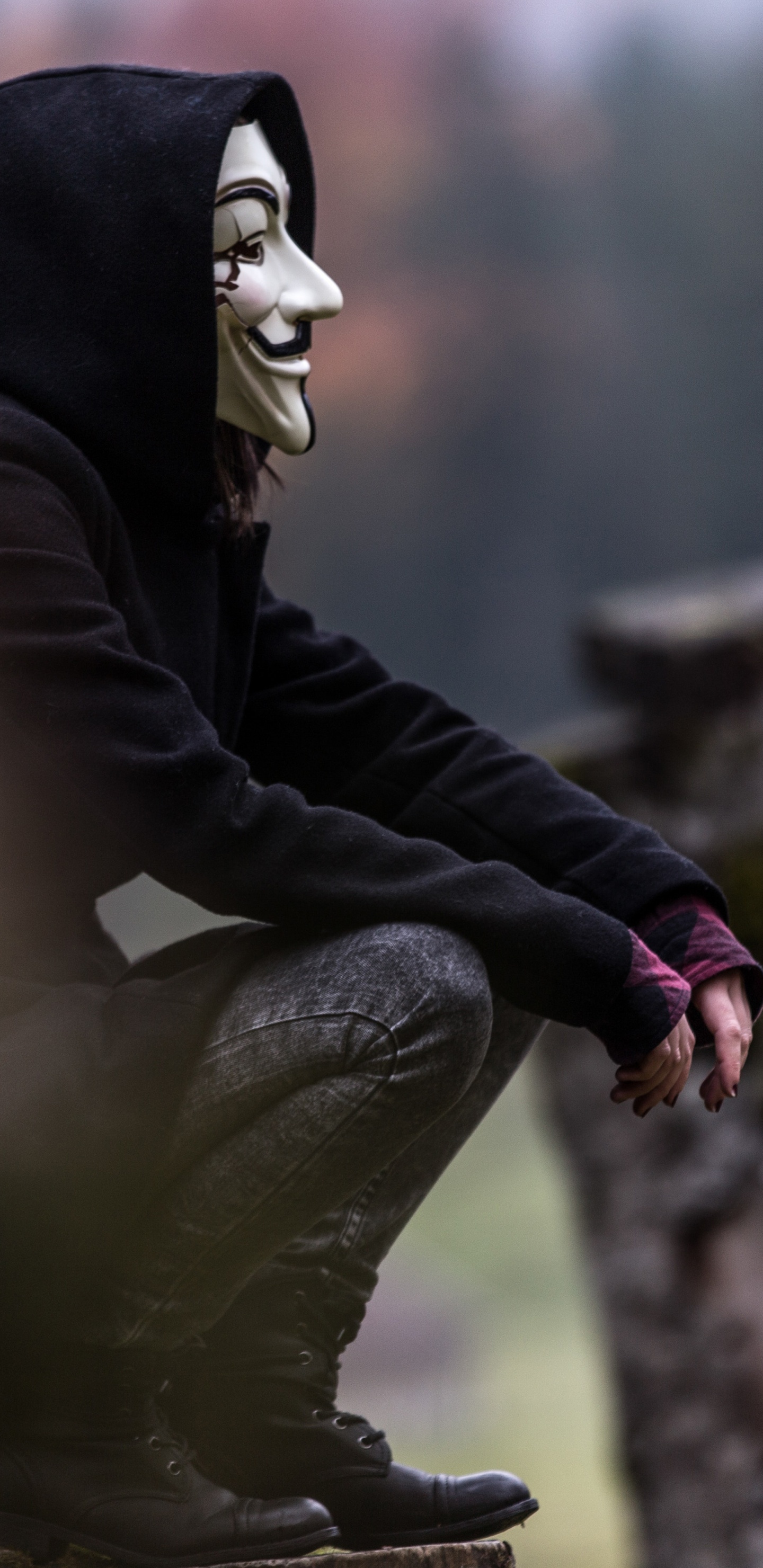 Person in Schwarz-weißer Maske Und Schwarzer Jacke, Die Auf Felsen Sitzt. Wallpaper in 1440x2960 Resolution