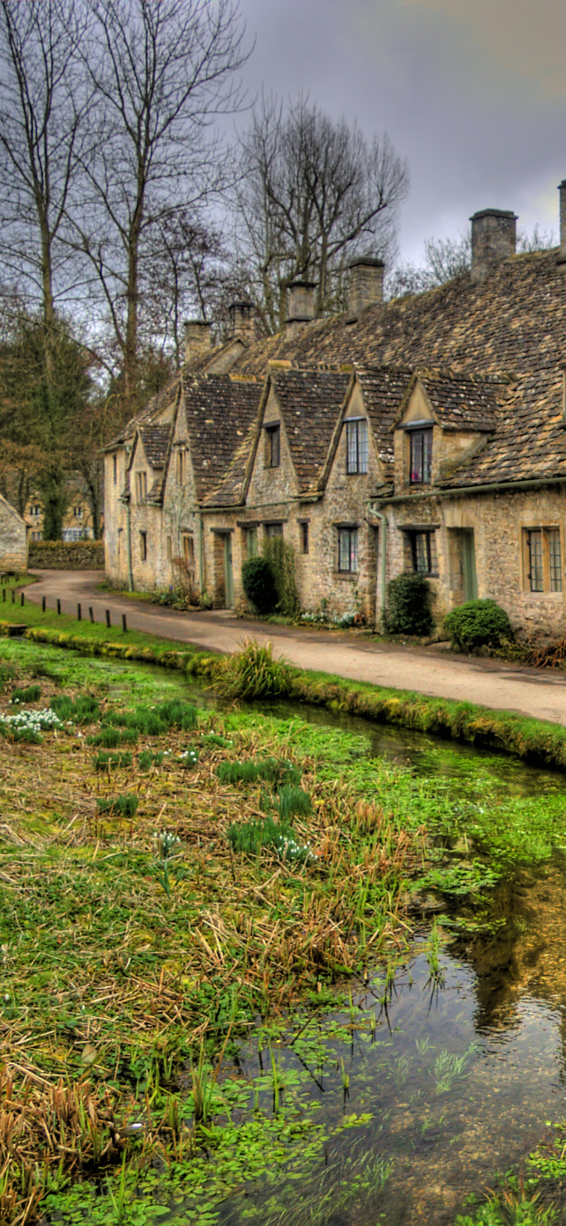 Brown Brick Building Near River. Wallpaper in 1125x2436 Resolution