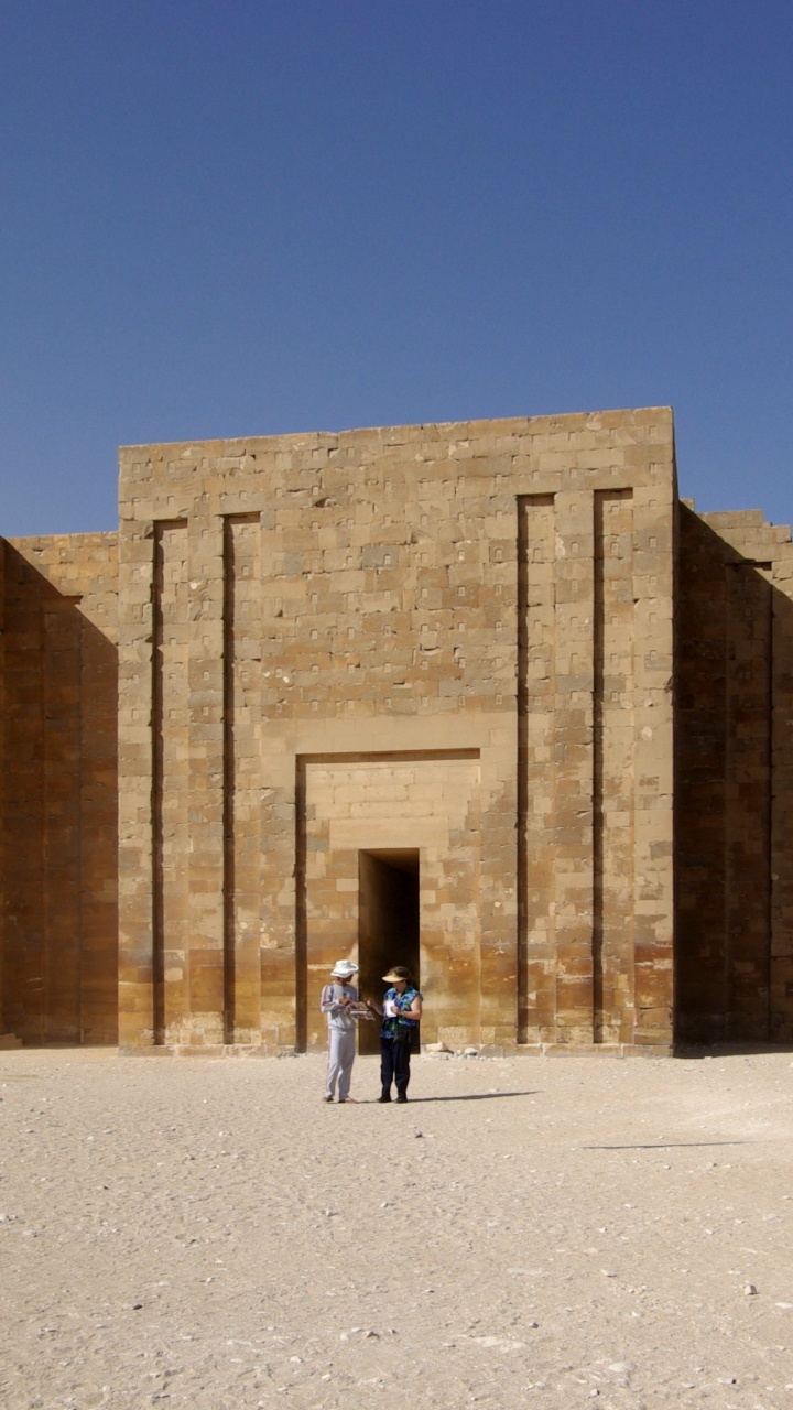 Personnes Marchant Près D'un Bâtiment en Béton Brun Pendant la Journée. Wallpaper in 720x1280 Resolution
