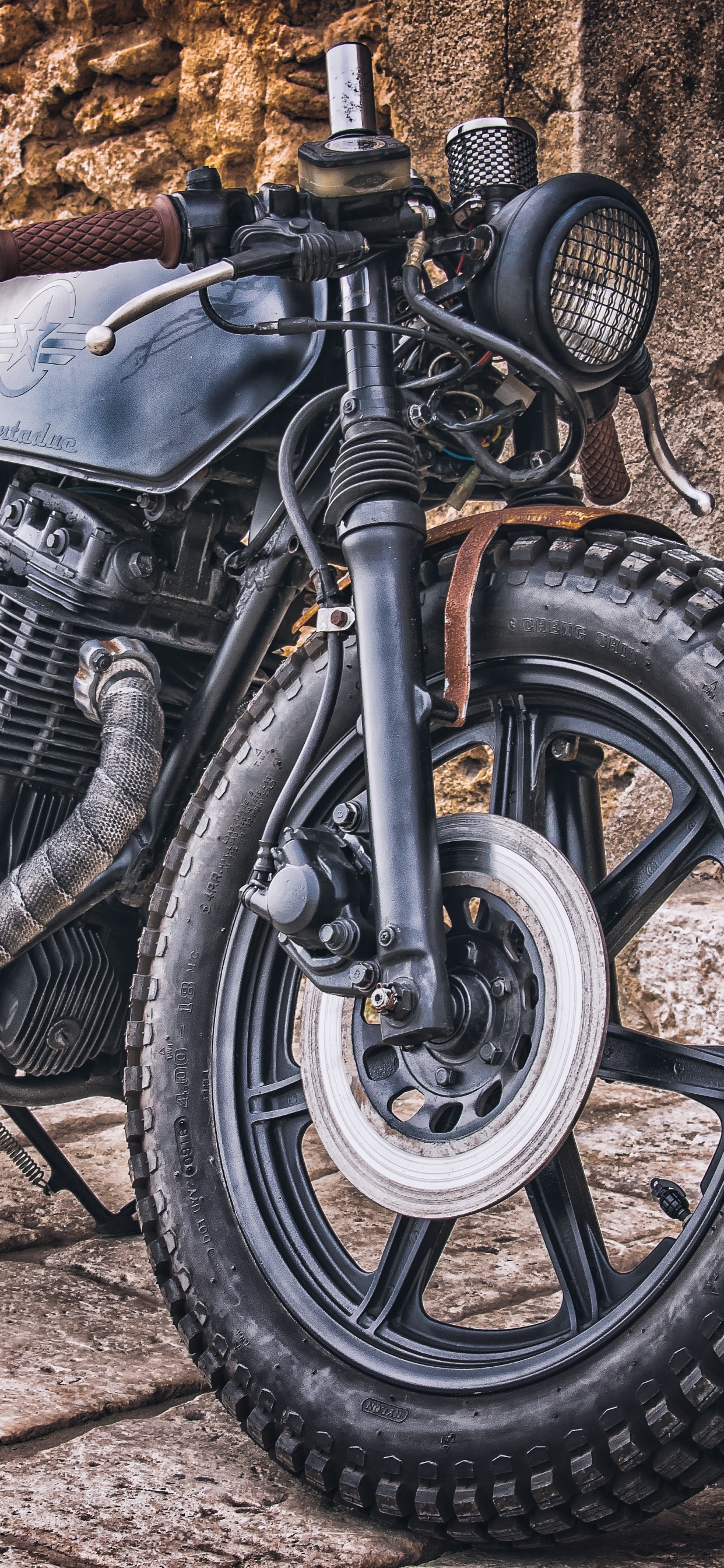 Schwarzes Und Silbernes Motorrad in Der Nähe Einer Braunen Holzwand. Wallpaper in 1242x2688 Resolution