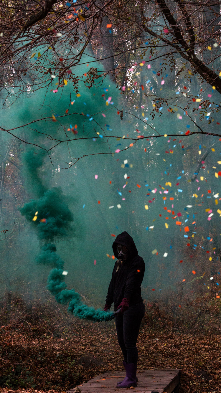 Woman in Black Jacket Standing Under Green and Pink String Lights. Wallpaper in 750x1334 Resolution