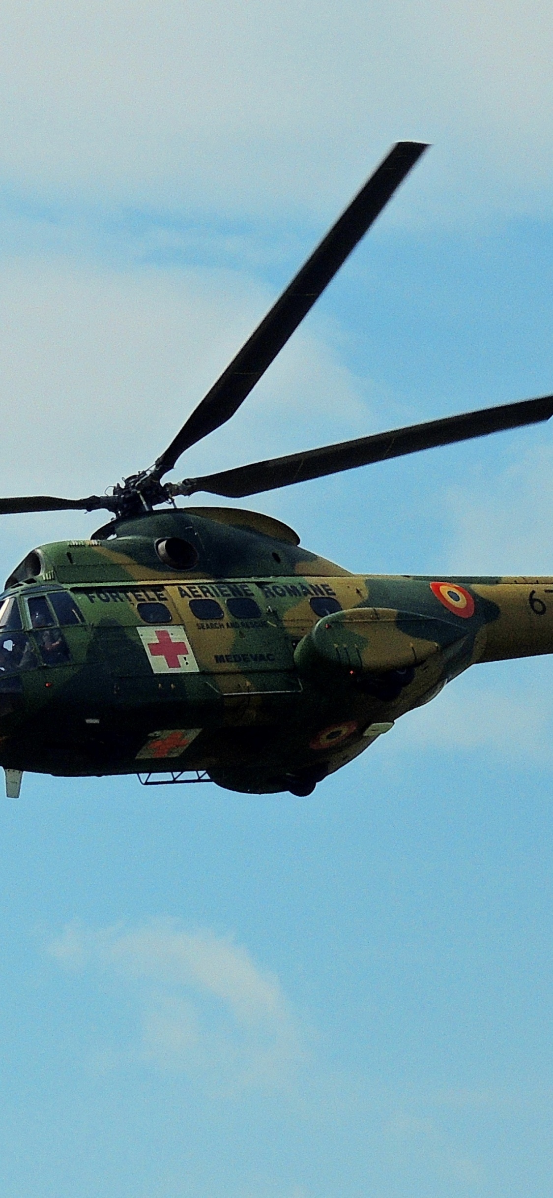 Hélicoptère Militaire de Camouflage Vert et Noir Volant Dans le Ciel. Wallpaper in 1125x2436 Resolution