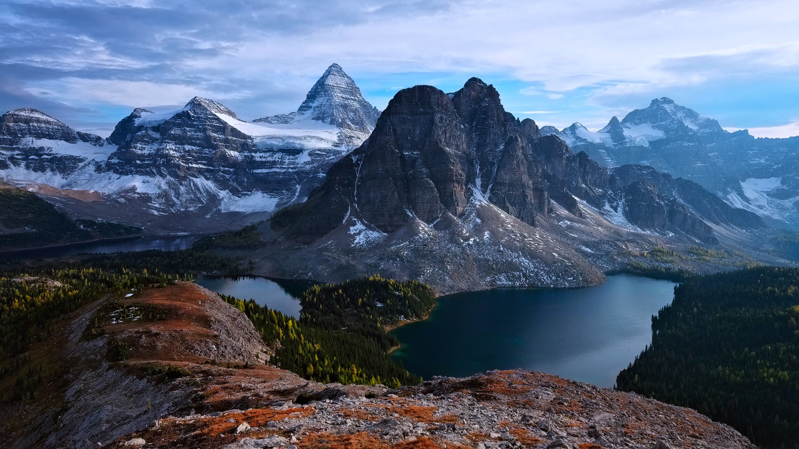 Snow Covered Mountain Near Lake Under Cloudy Sky During Daytime. Wallpaper in 2560x1440 Resolution