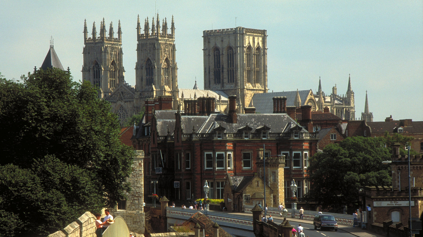 Voitures Garées Devant un Bâtiment en Béton Brun Pendant la Journée. Wallpaper in 1366x768 Resolution