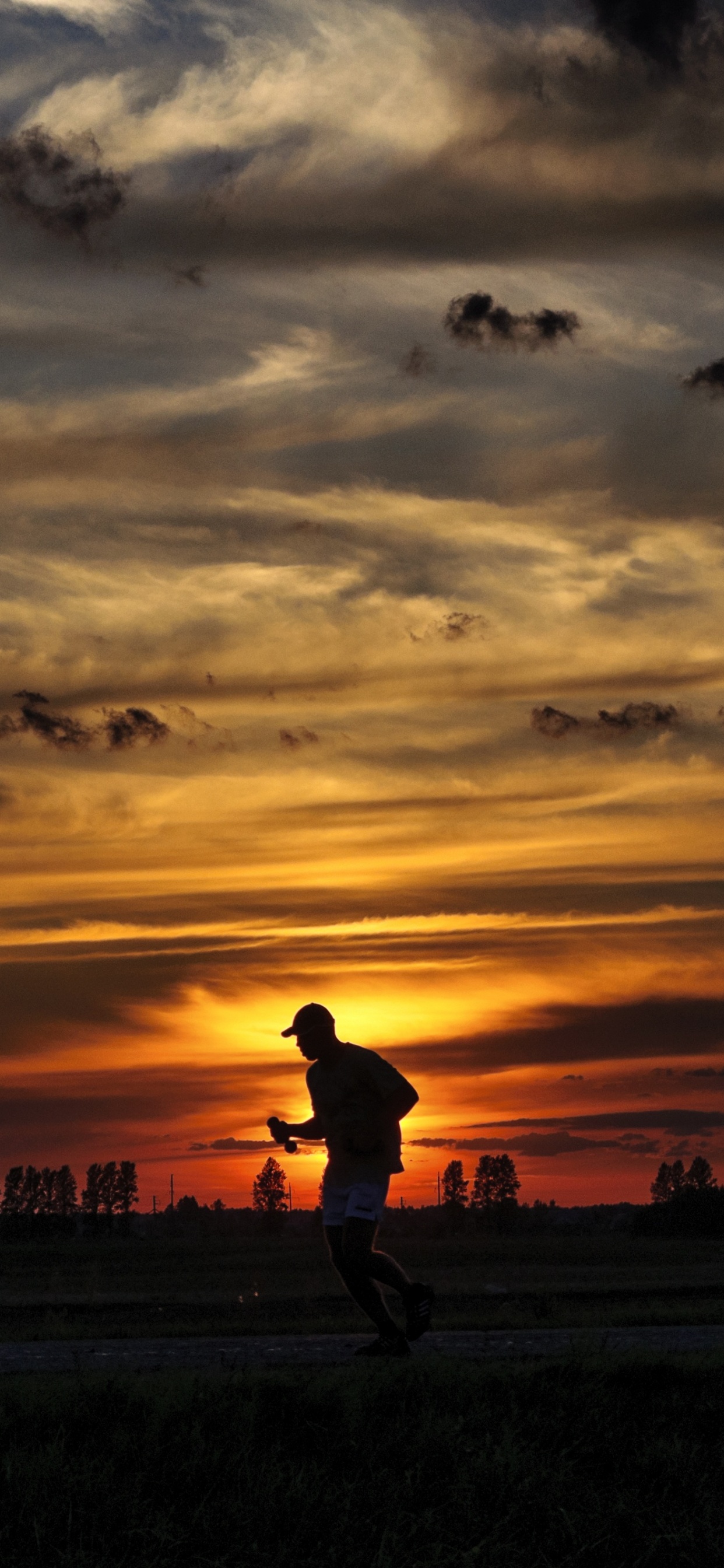 Silhouette D'homme Marchant Sur Terrain en Herbe Pendant le Coucher du Soleil. Wallpaper in 1242x2688 Resolution