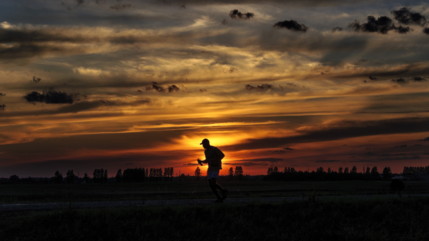 Silhouette D'homme Marchant Sur Terrain en Herbe Pendant le Coucher du Soleil. Wallpaper in 1366x768 Resolution