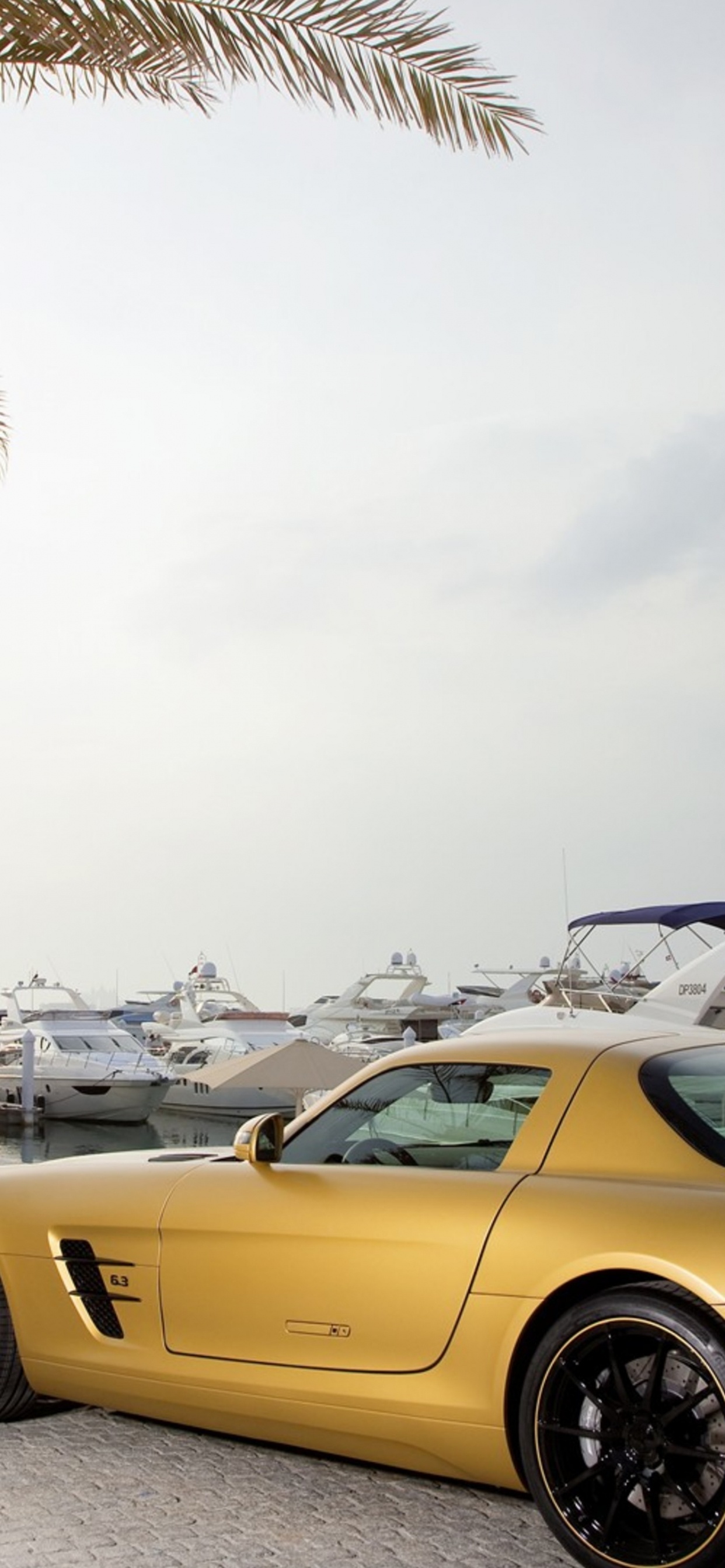 Porsche 911 Amarillo Estacionado Cerca de Palmeras y Edificios Durante el Día. Wallpaper in 1242x2688 Resolution