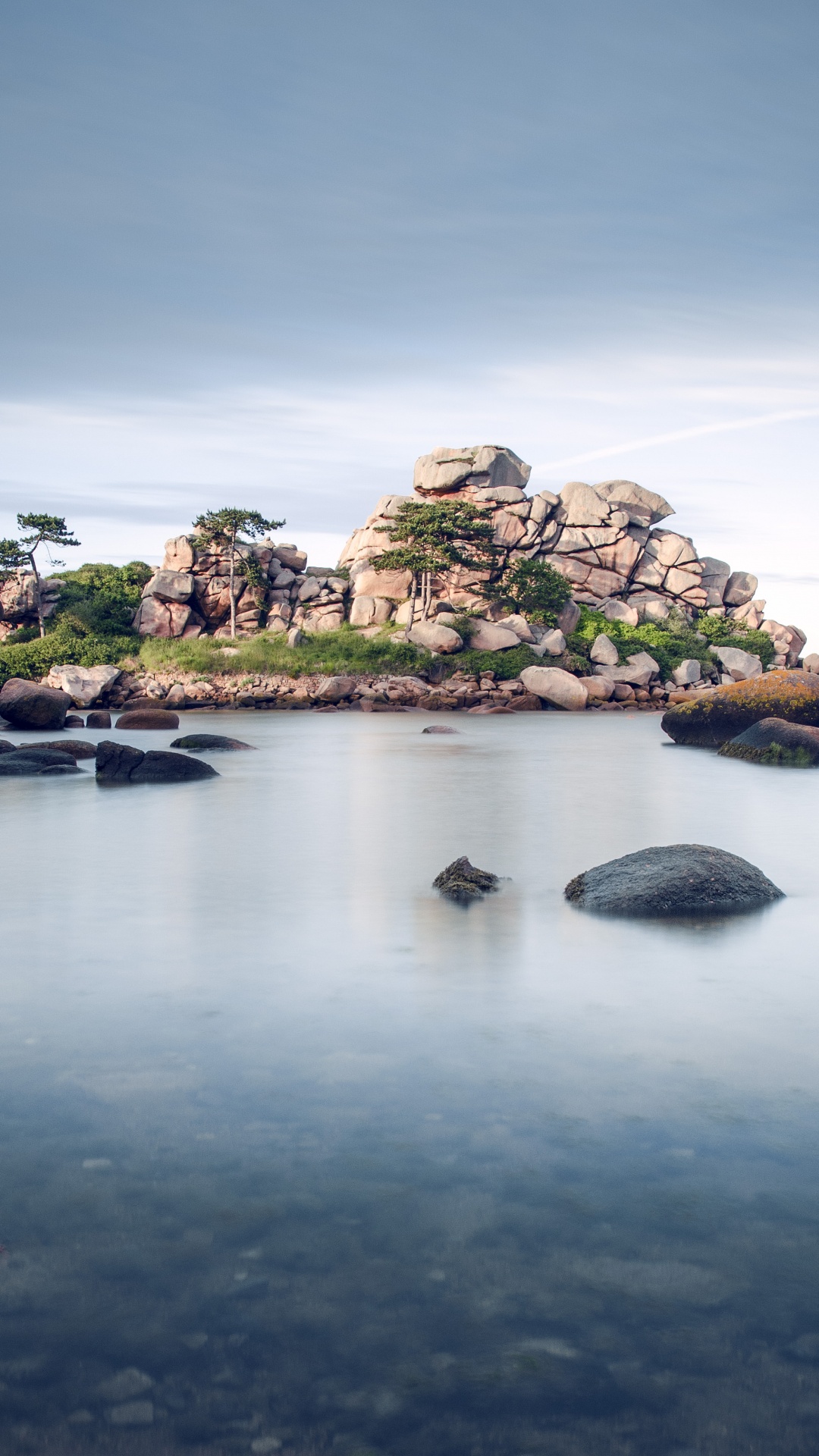 Green and Brown Rock Formation on Body of Water Under Blue Sky During Daytime. Wallpaper in 1080x1920 Resolution