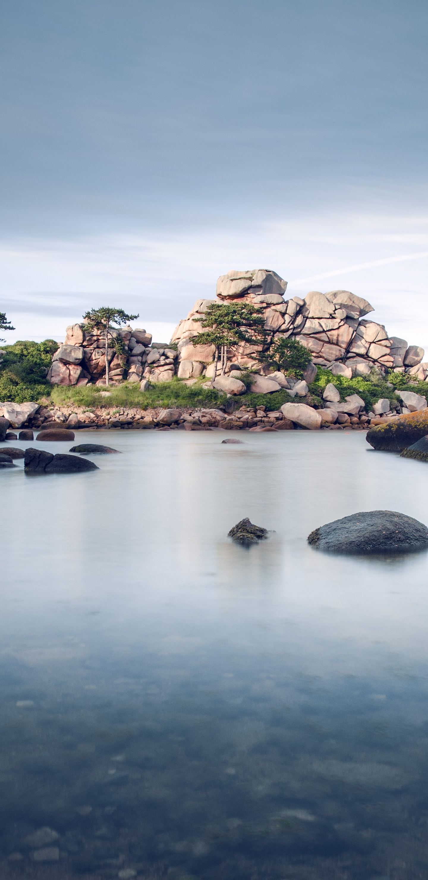 Green and Brown Rock Formation on Body of Water Under Blue Sky During Daytime. Wallpaper in 1440x2960 Resolution
