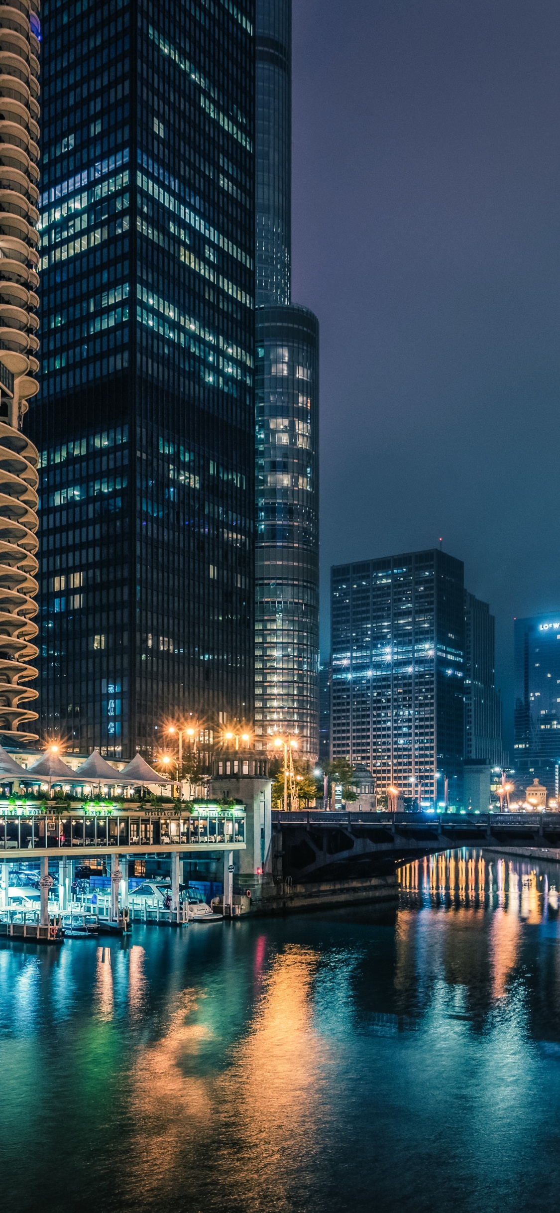 Body of Water Between High Rise Buildings During Night Time. Wallpaper in 1125x2436 Resolution