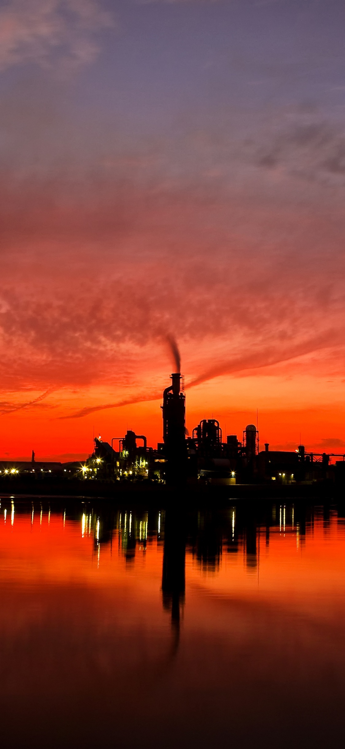 Silueta Del Edificio Cerca Del Cuerpo de Agua Durante la Puesta de Sol. Wallpaper in 1125x2436 Resolution