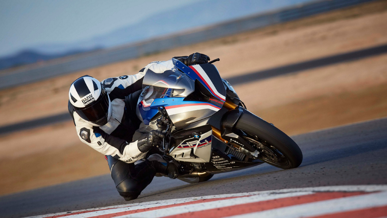 Man in Black and White Motorcycle Suit Riding on Sports Bike. Wallpaper in 1280x720 Resolution