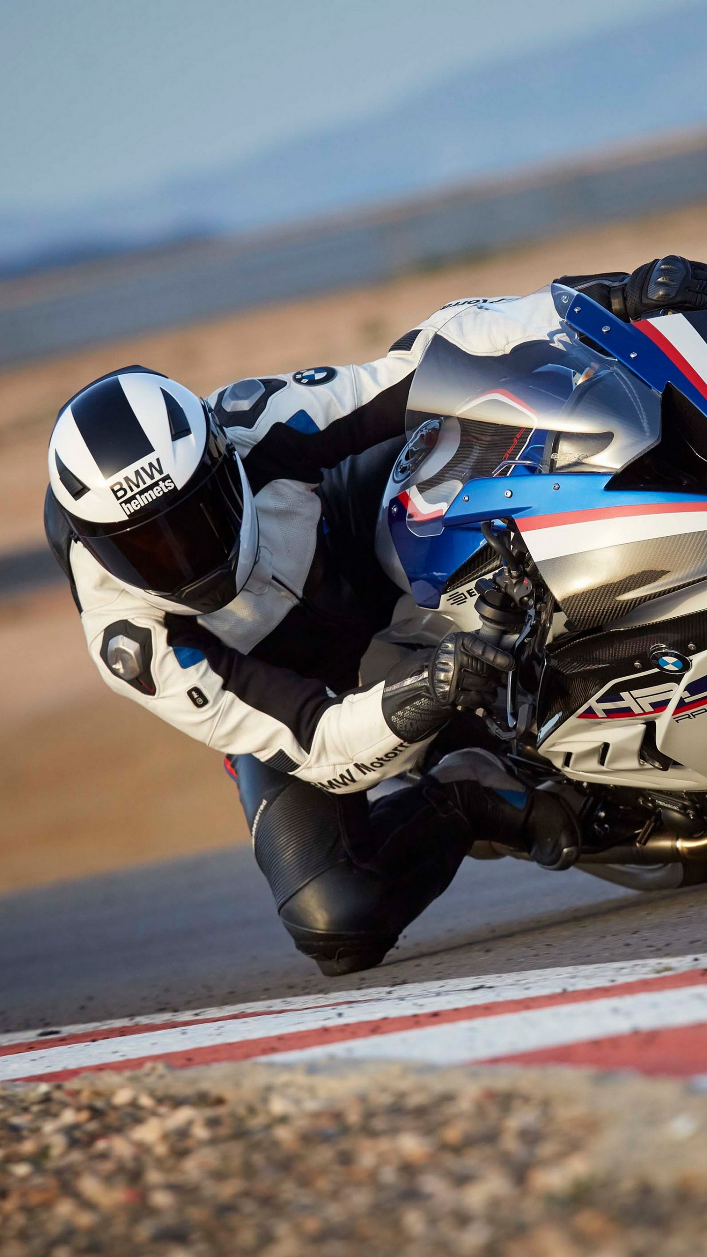 Homme en Costume de Moto Noir et Blanc à Cheval Sur un Vélo de Sport. Wallpaper in 1440x2560 Resolution