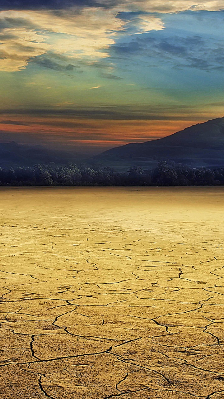 Braunes Feld in Der Nähe Eines Gewässers Während Des Sonnenuntergangs. Wallpaper in 720x1280 Resolution