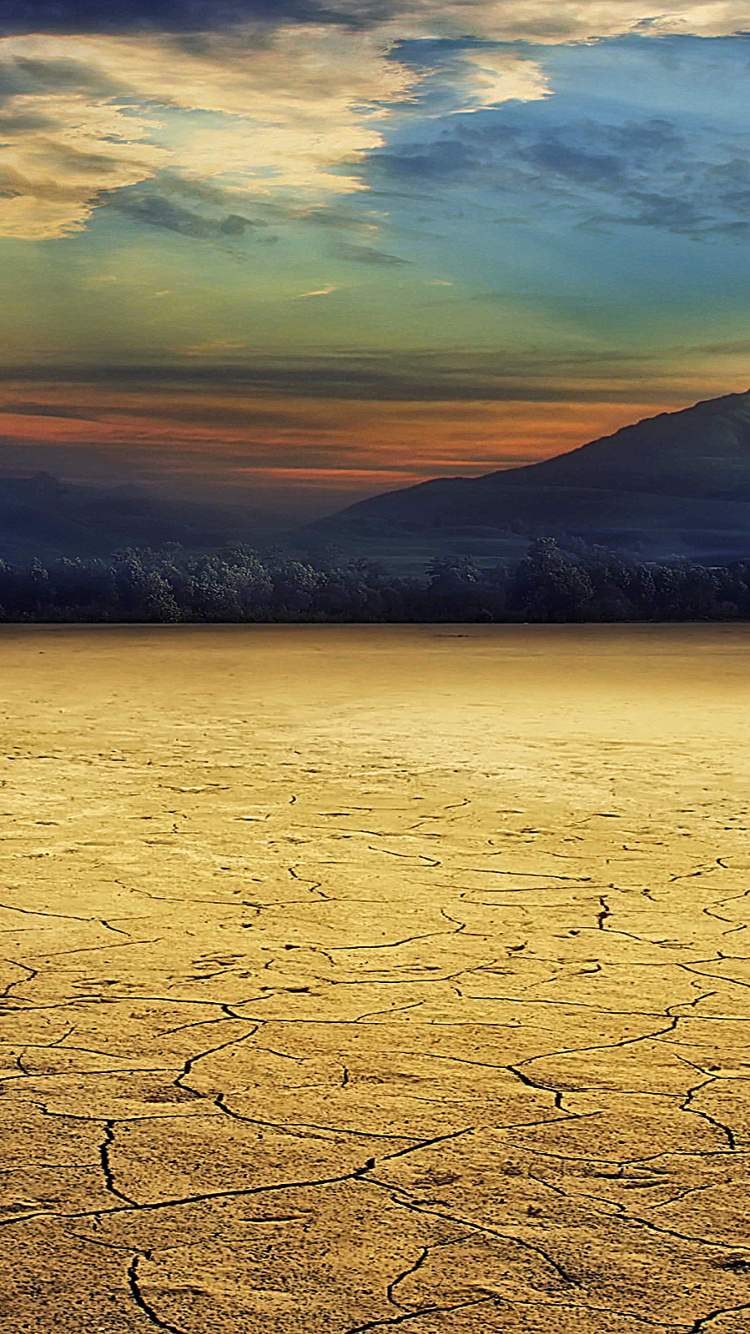 Brown Field Near Body of Water During Sunset. Wallpaper in 750x1334 Resolution