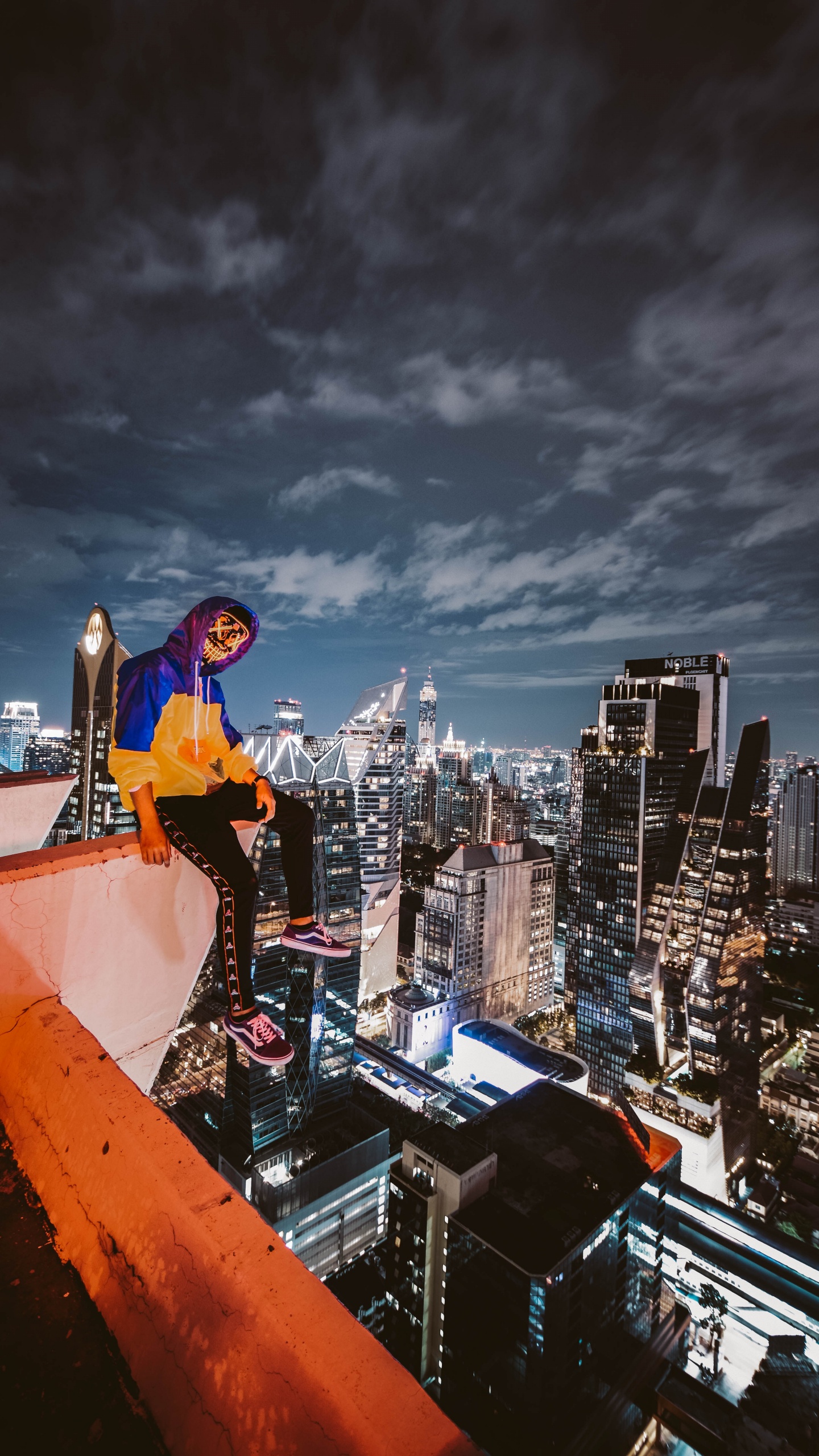 Man in Blue Long Sleeve Shirt and Black Pants Standing on Top of Building During Night. Wallpaper in 1440x2560 Resolution