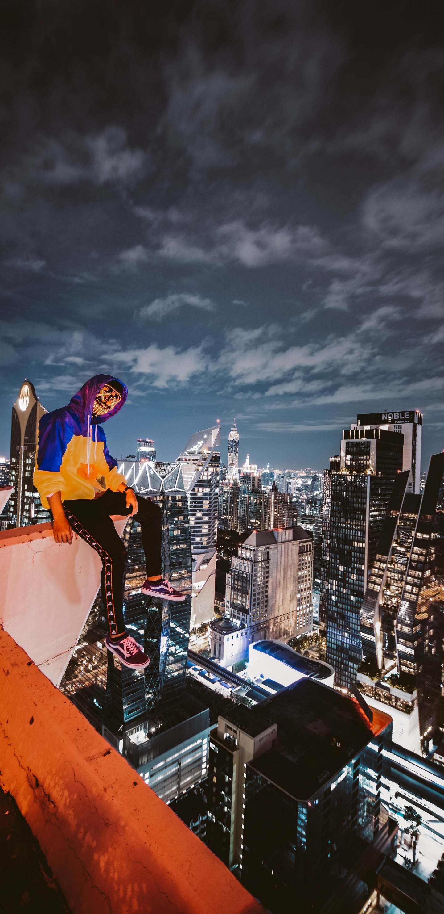 Hombre Con Camisa de Manga Larga Azul y Pantalón Negro de Pie en la Parte Superior Del Edificio Durante la Noche. Wallpaper in 1440x2960 Resolution