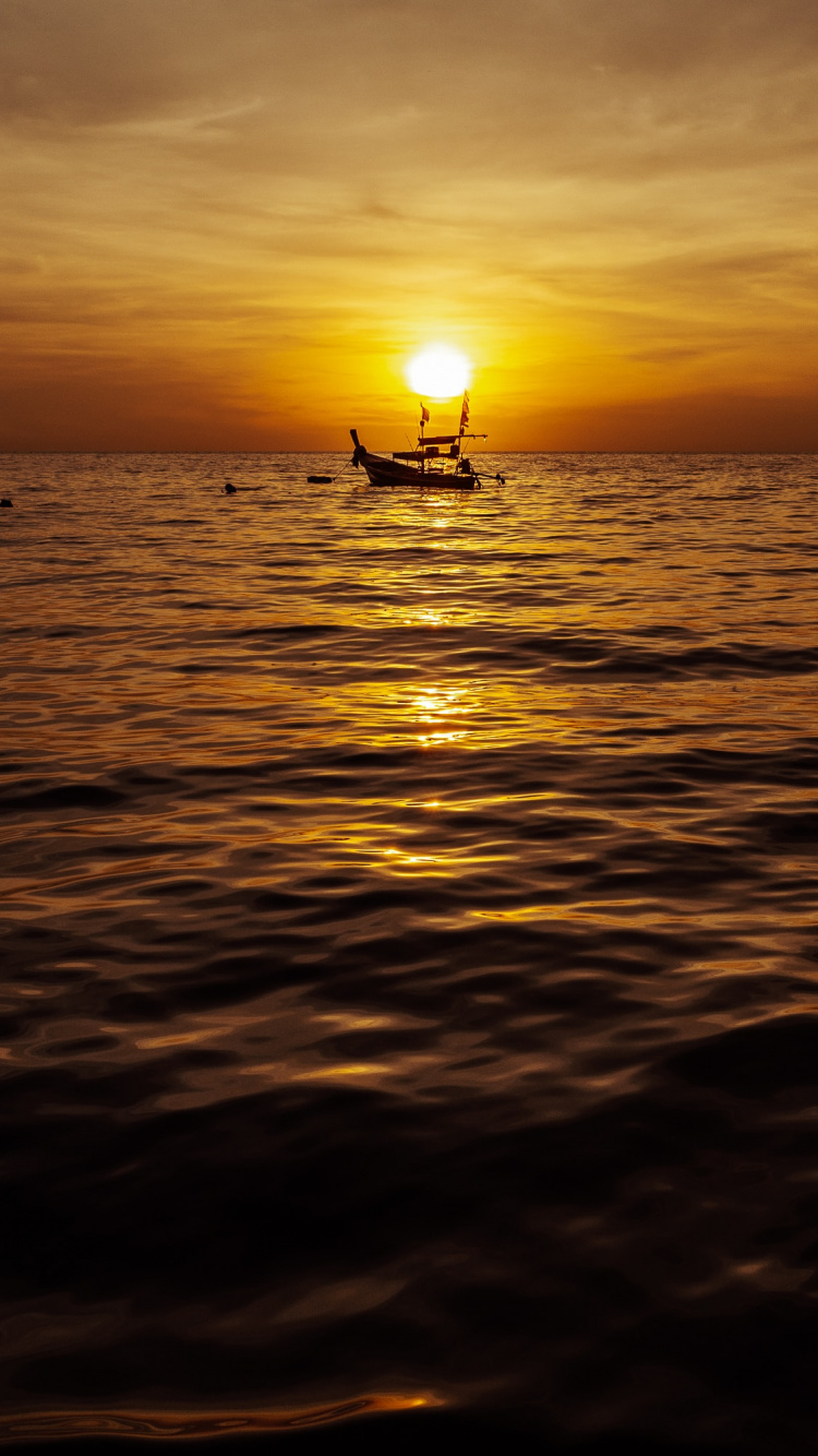 Silueta de Persona en el Mar Durante la Puesta de Sol. Wallpaper in 750x1334 Resolution