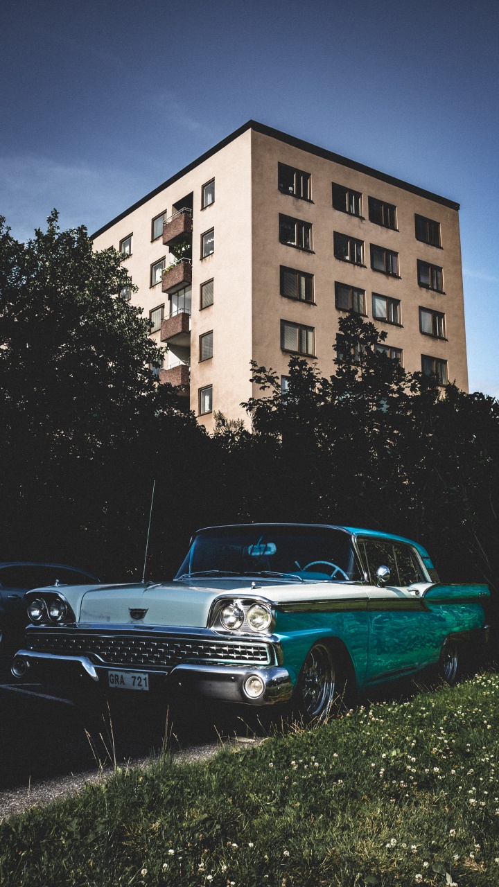 Blaue Limousine, Die Tagsüber Neben Einem Braunen Betongebäude Geparkt Ist?. Wallpaper in 720x1280 Resolution