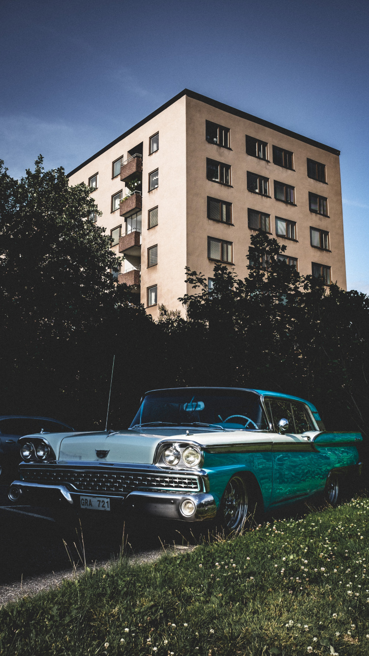 Blaue Limousine, Die Tagsüber Neben Einem Braunen Betongebäude Geparkt Ist?. Wallpaper in 750x1334 Resolution