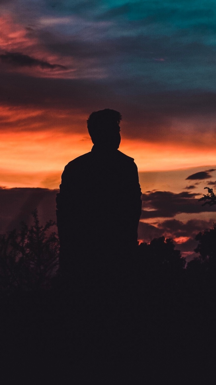 Silhouette D'homme Debout Sur Terrain en Herbe Pendant le Coucher du Soleil. Wallpaper in 720x1280 Resolution