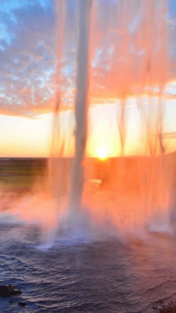 Gente Sentada Sobre Una Roca Cerca de Las Cascadas de Agua Durante el Día. Wallpaper in 750x1334 Resolution