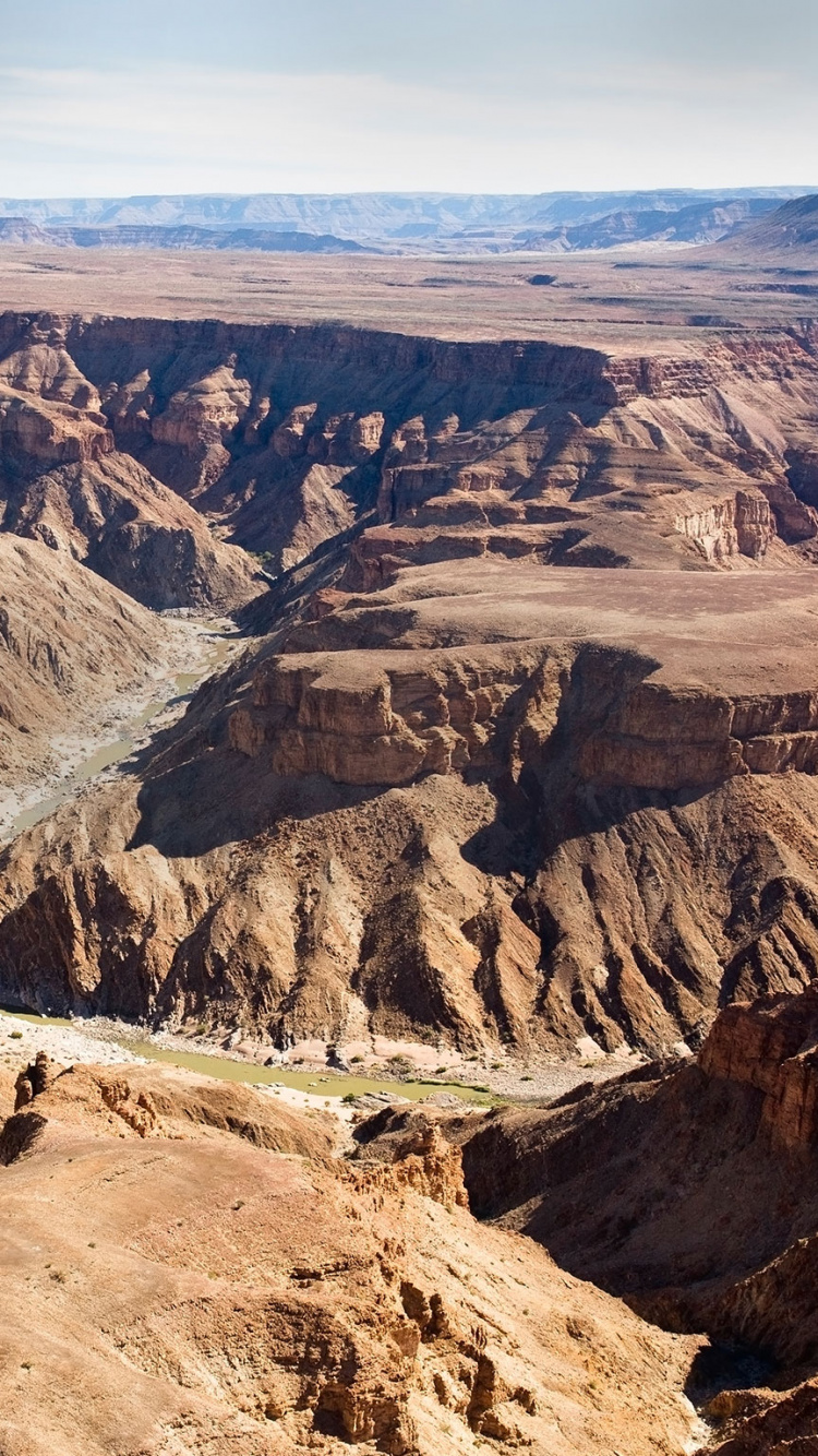 Brauner Felsiger Berg Unter Blauem Himmel Tagsüber. Wallpaper in 750x1334 Resolution