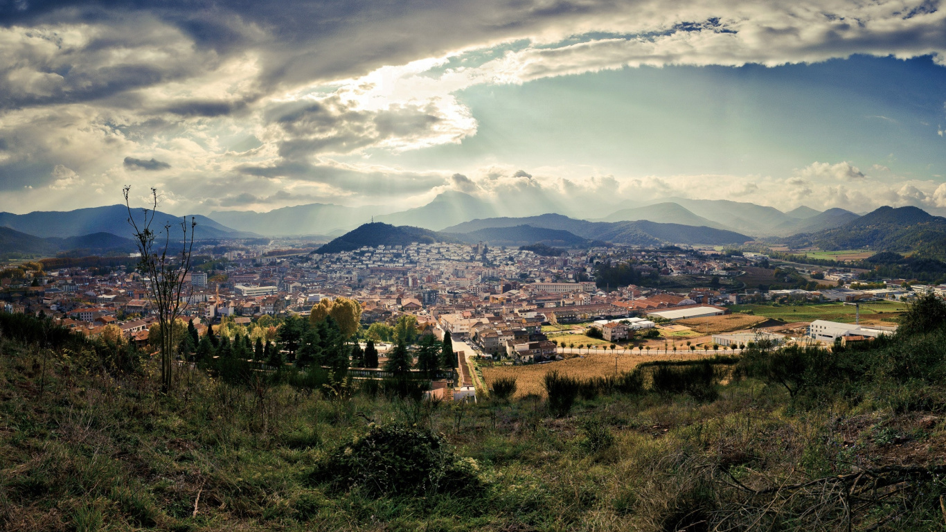 Campo de Hierba Verde Cerca de Los Edificios de la Ciudad Bajo Las Nubes Blancas y el Cielo Azul Durante el Día. Wallpaper in 1366x768 Resolution