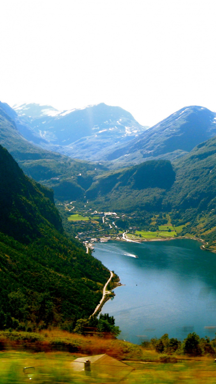 Green Mountains Near Lake Under White Sky During Daytime. Wallpaper in 750x1334 Resolution