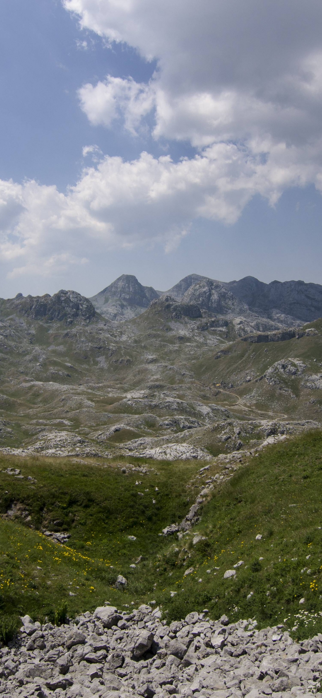 Grüne Und Graue Berge Unter Weißen Wolken Und Blauem Himmel Tagsüber. Wallpaper in 1125x2436 Resolution