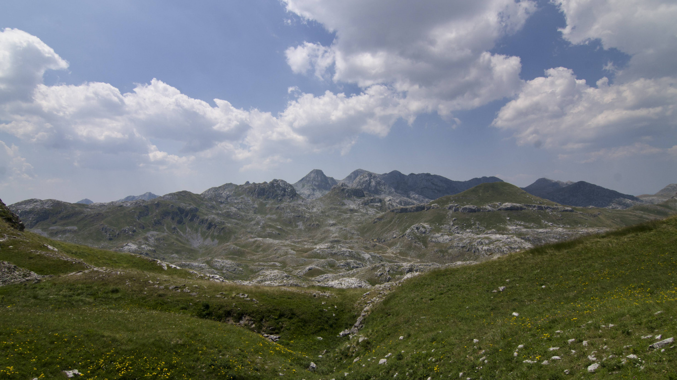 Grüne Und Graue Berge Unter Weißen Wolken Und Blauem Himmel Tagsüber. Wallpaper in 1366x768 Resolution