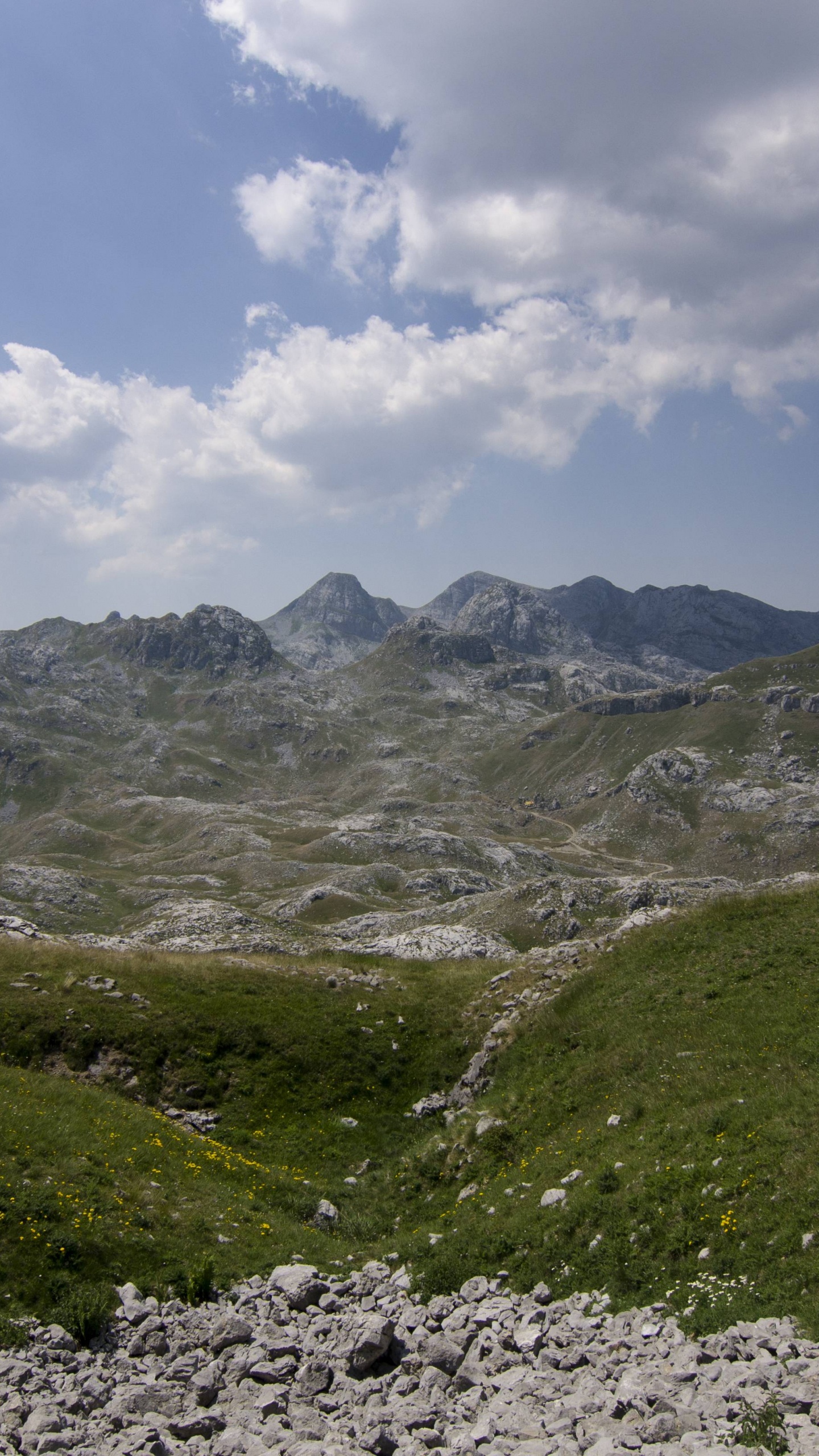 Grüne Und Graue Berge Unter Weißen Wolken Und Blauem Himmel Tagsüber. Wallpaper in 1440x2560 Resolution