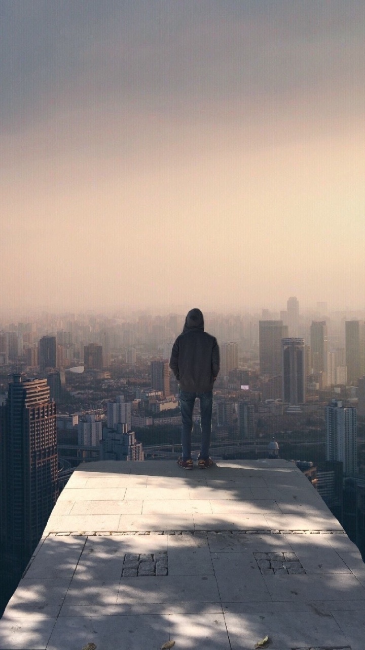 Mann in Schwarzer Jacke, Der Tagsüber Auf Dem Gebäude Steht. Wallpaper in 720x1280 Resolution