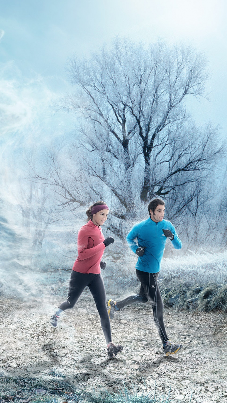 Hombre Con Camiseta Azul y Pantalón Negro de Pie Sobre la Arena Gris Cerca Del Humo Blanco Durante. Wallpaper in 750x1334 Resolution