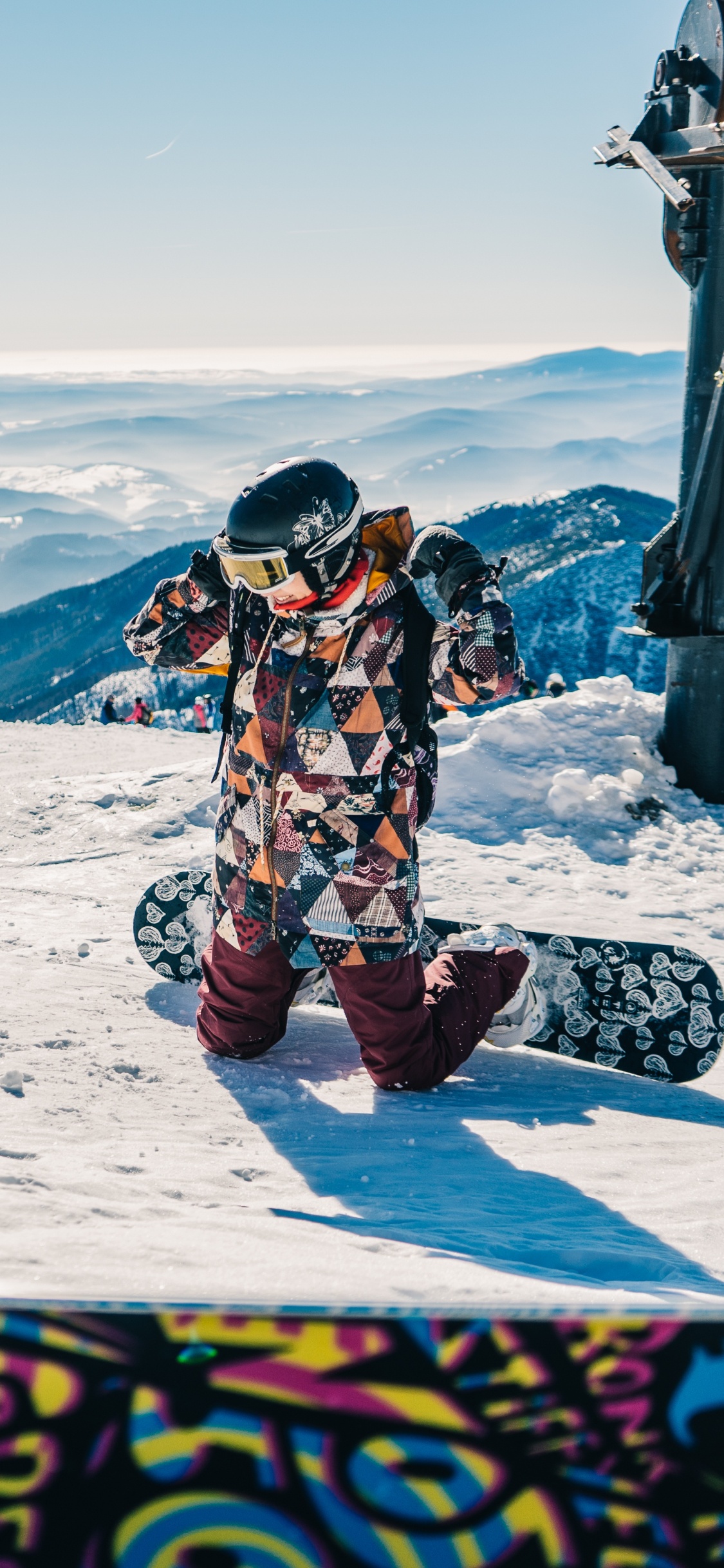 Man in Black and White Jacket Sitting on Snow Covered Mountain During Daytime. Wallpaper in 1125x2436 Resolution