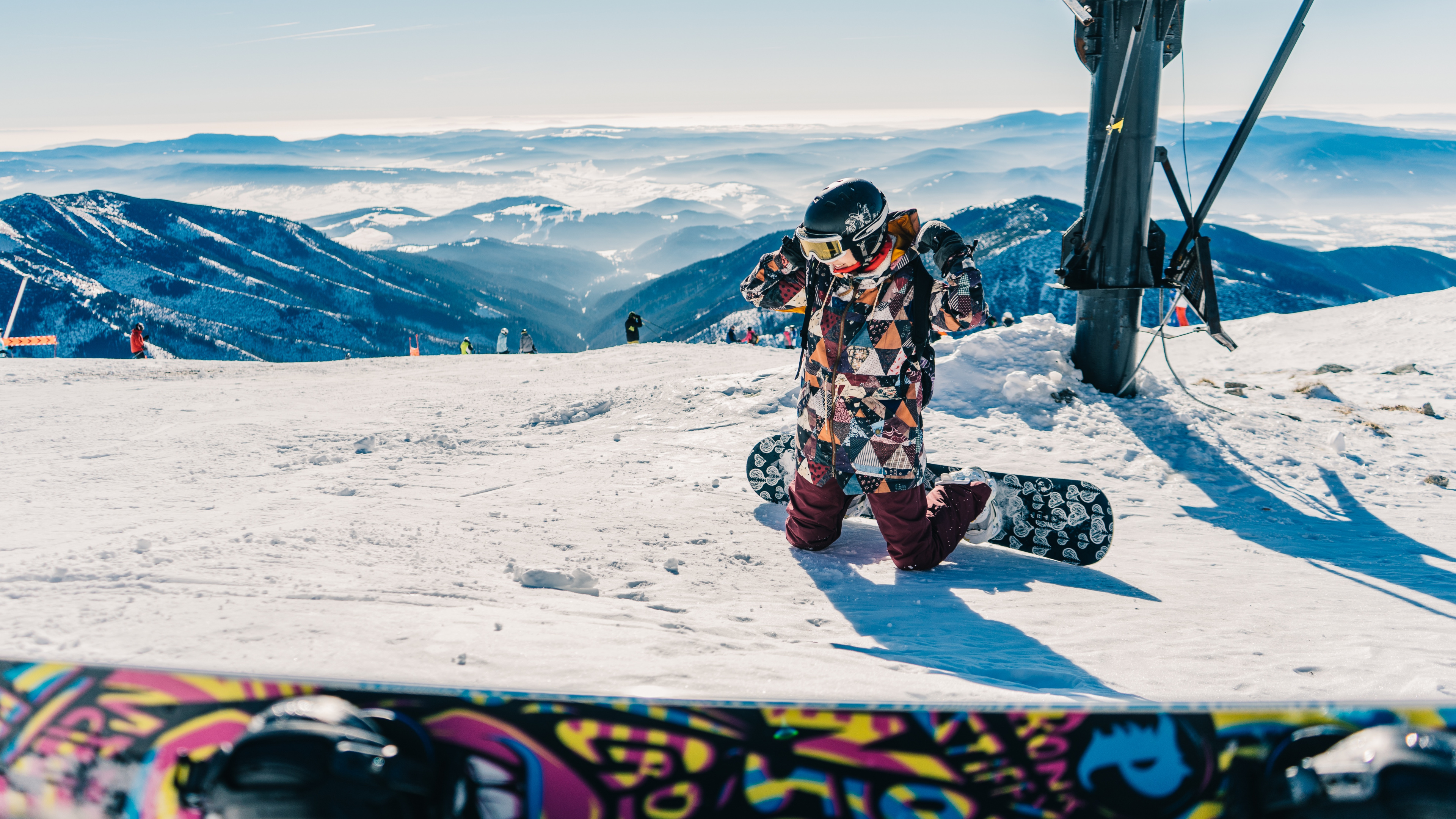 L'homme en Veste Noire et Blanche Assis Sur la Montagne Couverte de Neige Pendant la Journée. Wallpaper in 3840x2160 Resolution