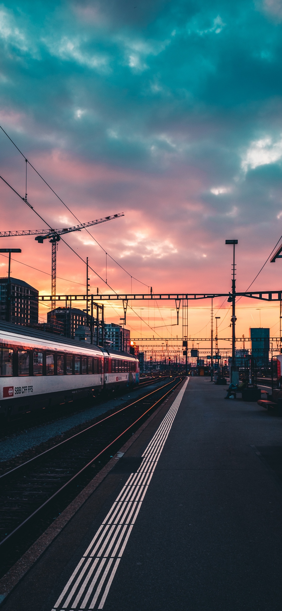 Red and White Train on Rail Road During Sunset. Wallpaper in 1125x2436 Resolution