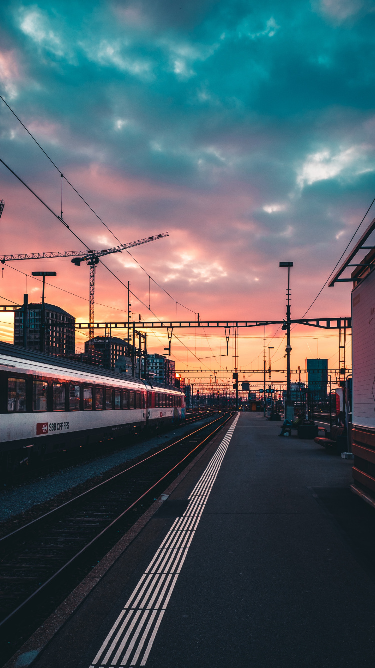 Train Rouge et Blanc Sur Chemin de Fer Pendant le Coucher du Soleil. Wallpaper in 750x1334 Resolution